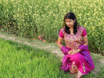 Portrait of woman sitting on field