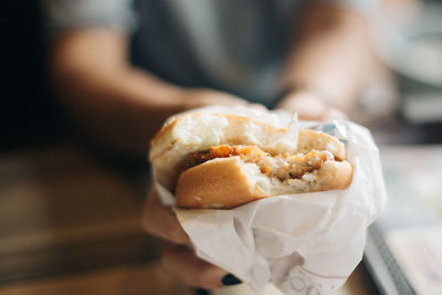 Midsection of woman holding burger