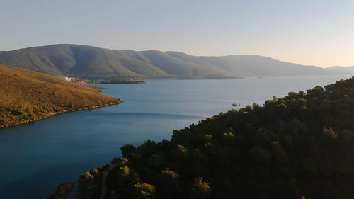 Scenic view of sea and mountains against clear sky