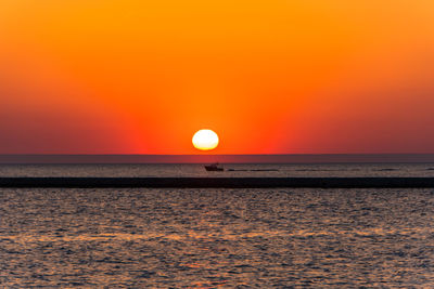 Scenic view of sea against orange sky