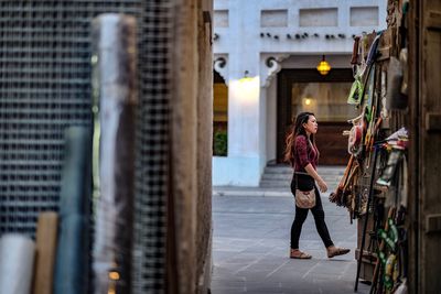 Full length of woman on footpath against building in city