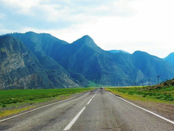 Empty road leading towards mountains