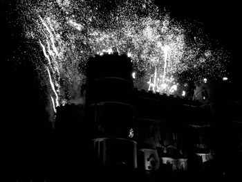 Low angle view of firework display at night