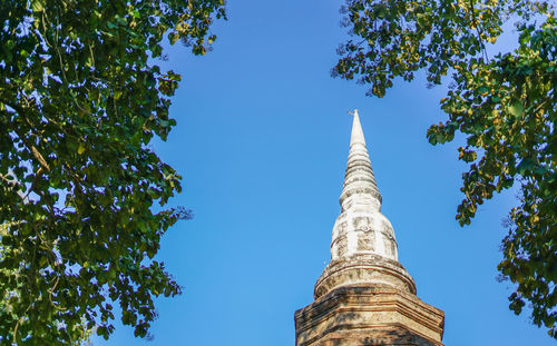 Low angle view of trees and building against sky