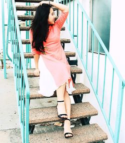 Full length of young woman standing on staircase