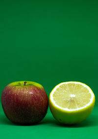 Close-up of apple on table against green background