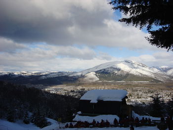 Panoramic view of people in snow against sky