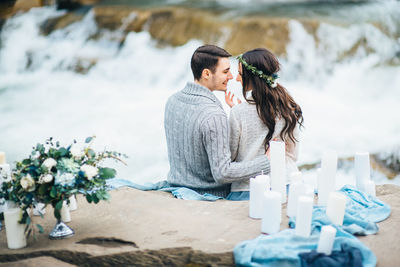 Rear view of couple sitting on shore