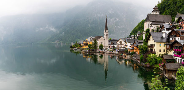 Panoramic view of buildings and lake during foggy weather