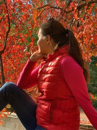 Rear view of girl on red autumn leaves
