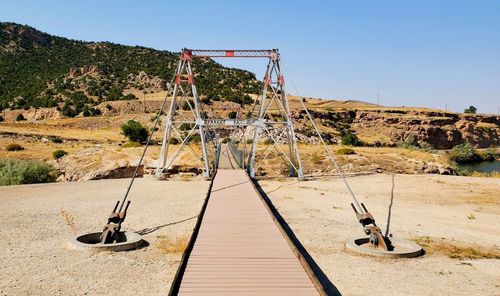 Metal structure on field against clear sky