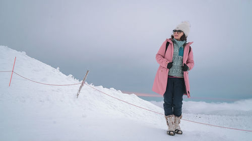 Rear view of woman standing on snow