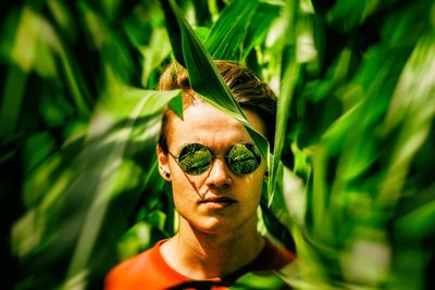 Close-up portrait of young man amidst plants