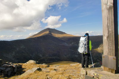 Rear view of man looking at mountain against sky