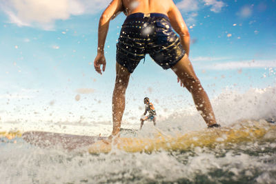 Low angle view of man splashing water at beach