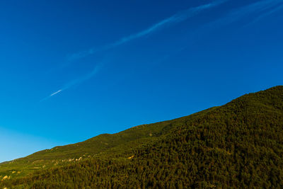 Low angle view of mountain against blue sky