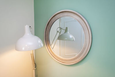 Illuminated desk lamp reflecting on mirror at home