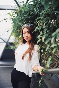 Portrait of woman standing against plants