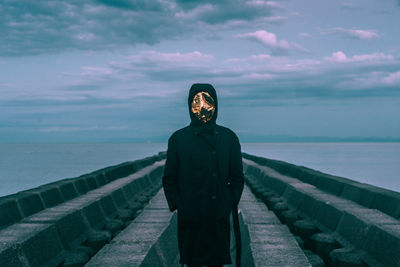 Man standing by sea against sky