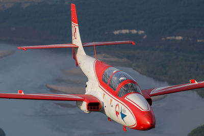 Red airplane flying over mountains