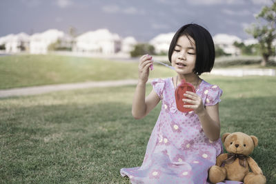 Full length of a girl with toy on field