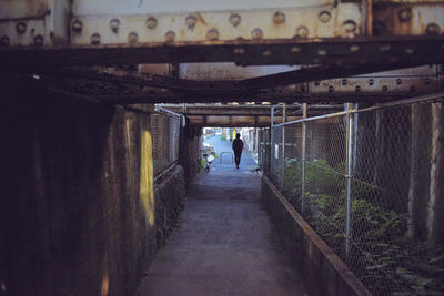 Rear view of people walking in tunnel