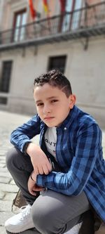 Cute boy sitting outdoors