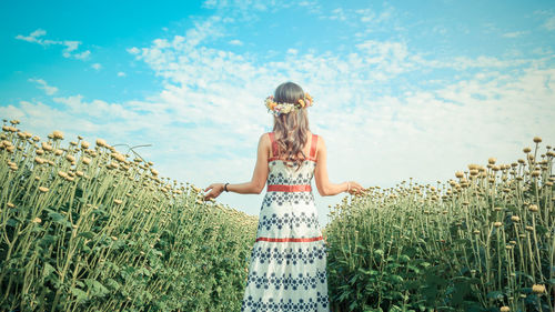 Woman standing on field against sky