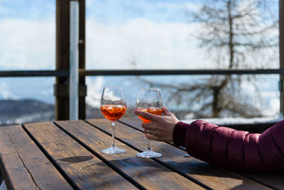 Close-up of hand holding glass on table