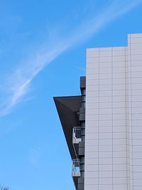 Low angle view of modern building against blue sky