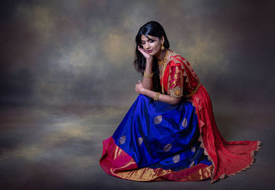 Young woman standing against the wall