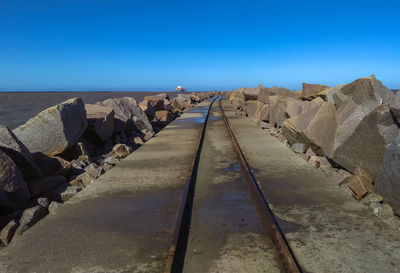 Panoramic view of railroad tracks against clear blue sky