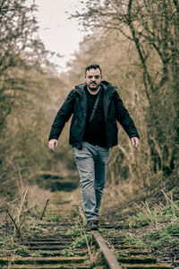 Portrait of young man standing in forest