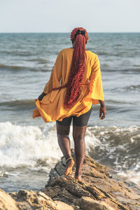 Woman with umbrella standing on beach