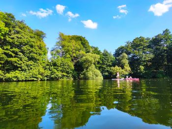 Scenic view of lake by trees against sky