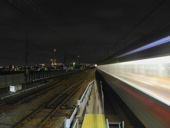 Train at railroad station against sky at night