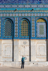 Full length of woman standing against historic building