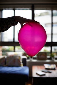 Close-up of pink balloon hanging on window