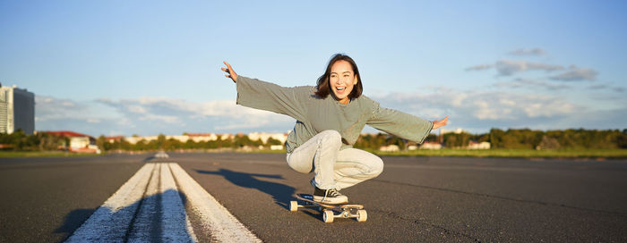 Rear view of woman standing on road against sky