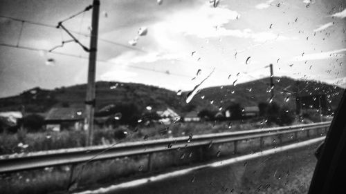 Road seen through wet glass window