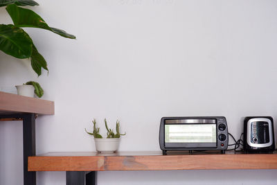 Potted plant on table against wall at home