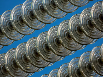 Low angle view of spiral metal against blue sky