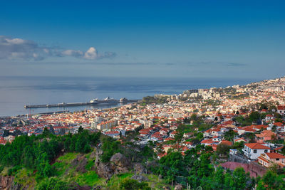 High angle view of townscape by sea against sky