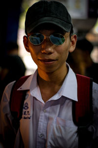 Portrait of young man wearing sunglasses at night