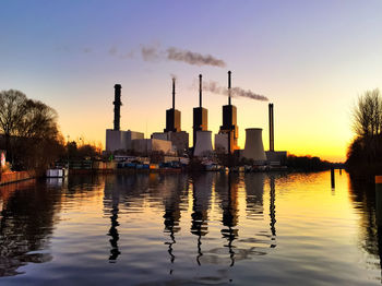 Reflection of silhouette city on lake at sunset