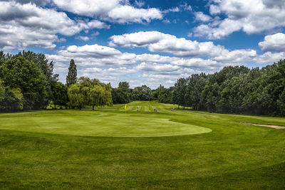 Scenic view of golf course against sky