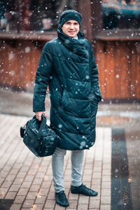 Full length portrait of woman standing in snow