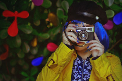 Close-up of young woman holding camera