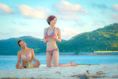 Female friends wearing bikini at beach