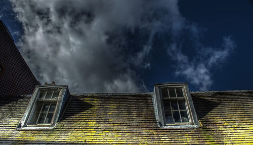 Low angle view of storm clouds over house